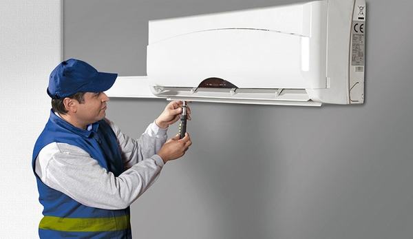 Técnico instalando um aparelho de ar-condicionado na parede